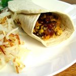 Chorizo shown in a plate of chorizo con huevos with hash browns