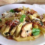 Penne and smoked chicken on a white plate