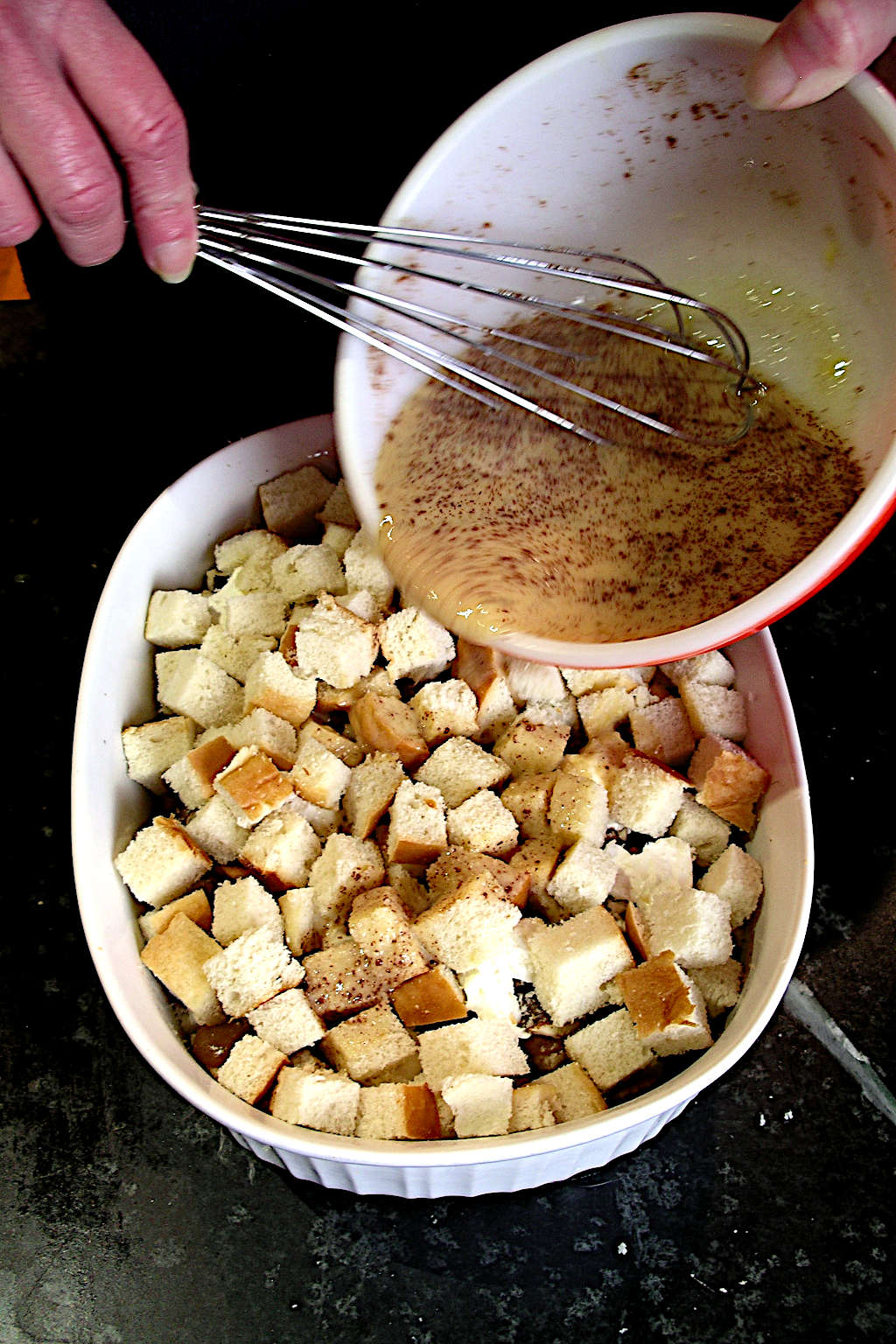 pouring egg mixture over strata